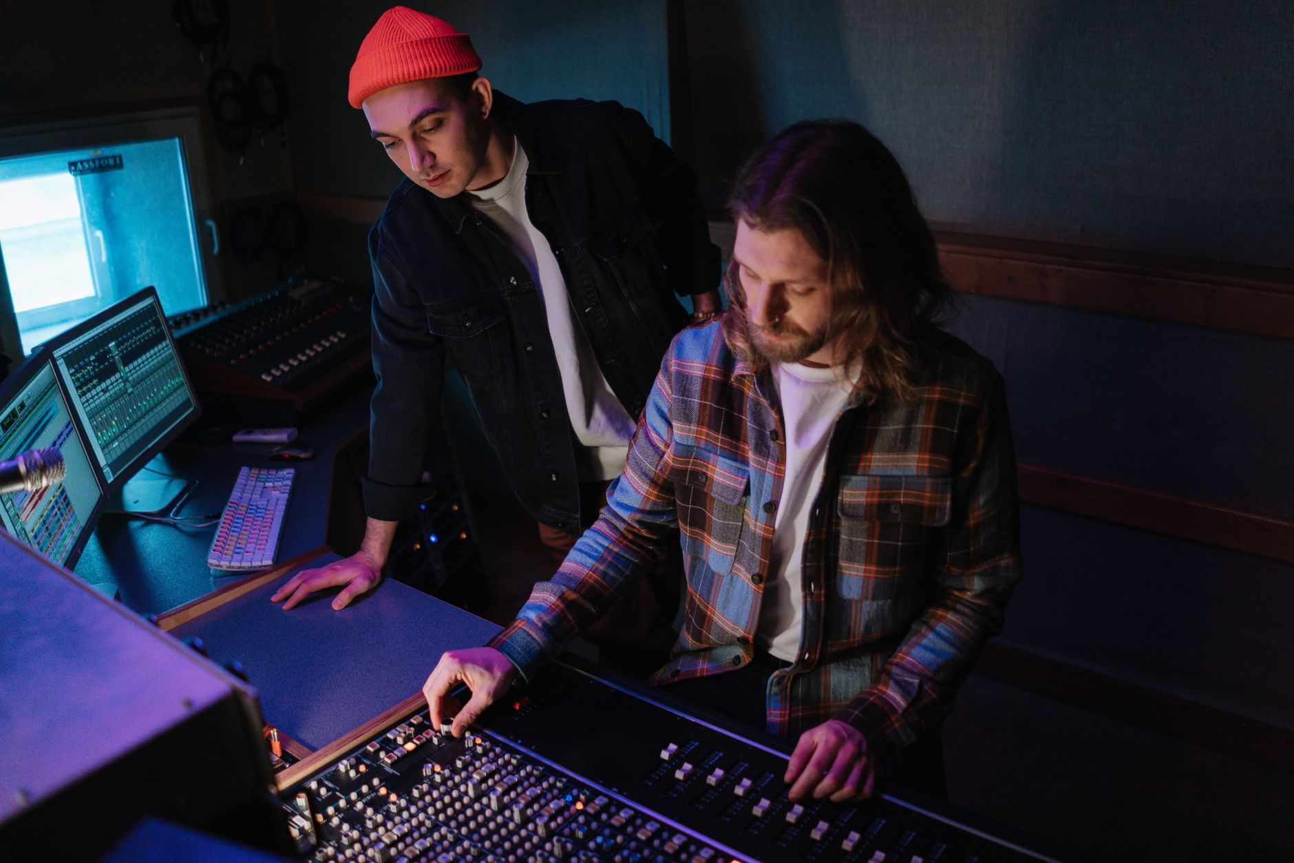 Two people working together at a studio mixing console