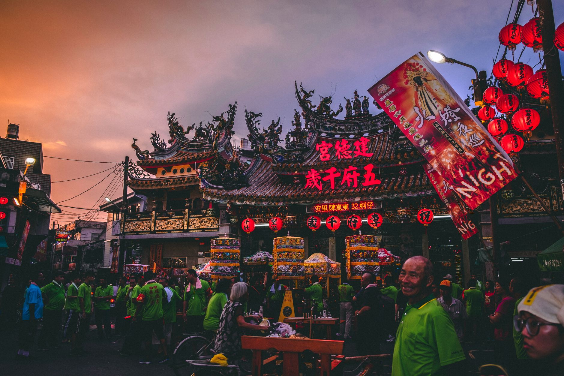 Festival crowd facing a main stage at dusk
