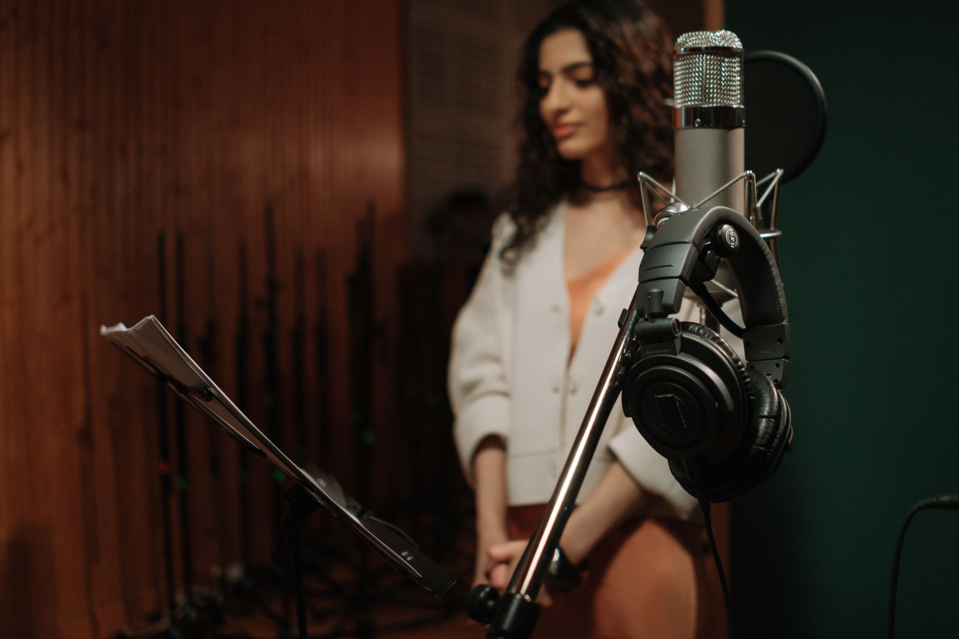 A vocal microphone and headphones set up in a studio live room