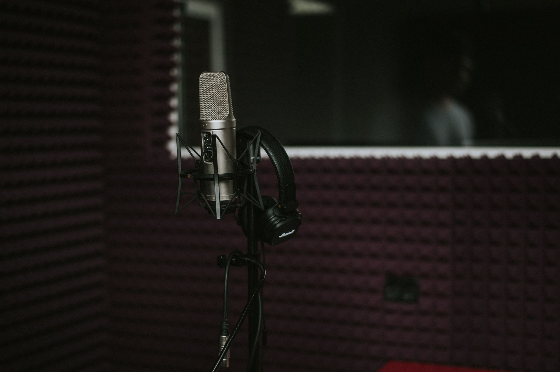 Session guitarist recording in a professional studio booth
