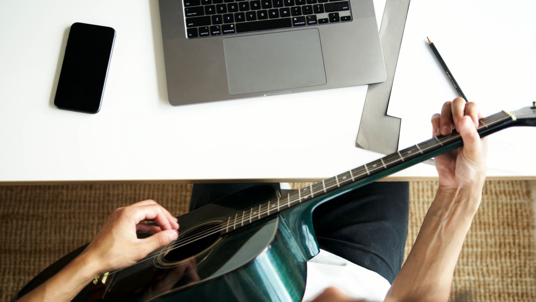 songwriter in home studio with laptop