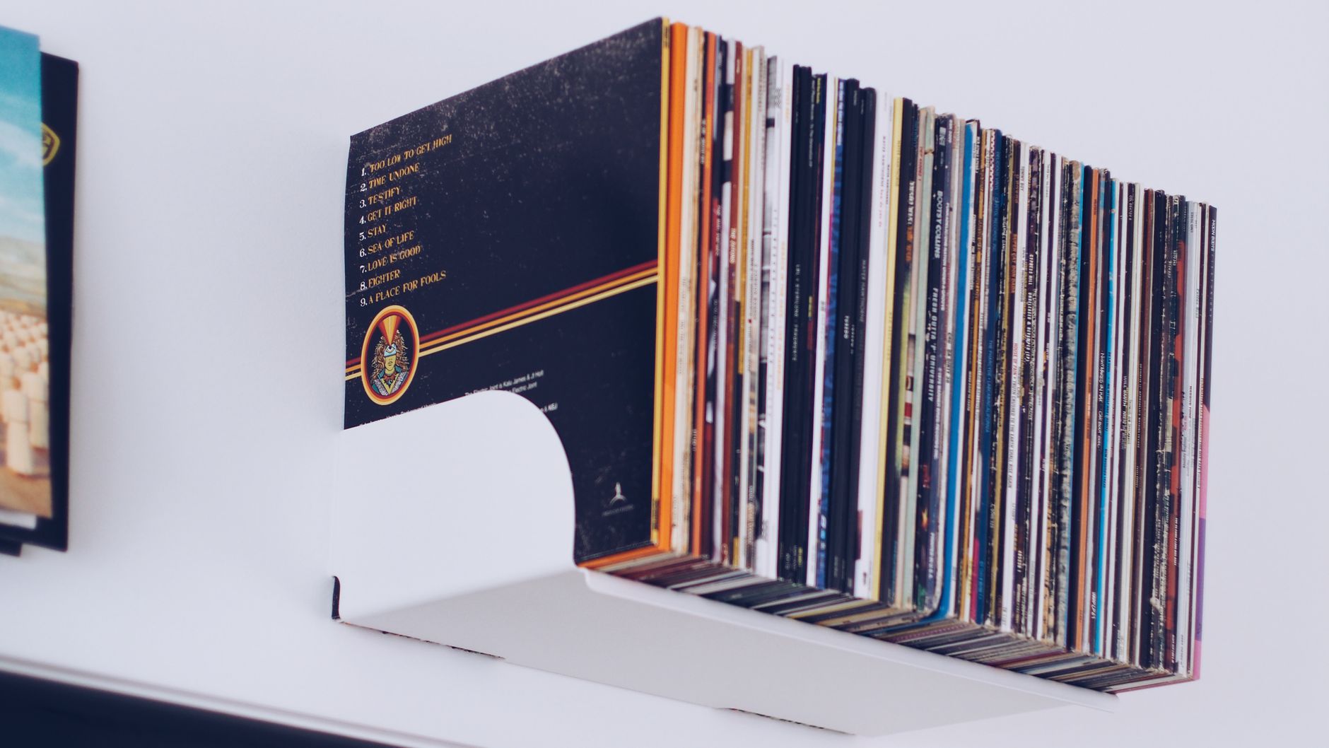 Records filed on a shelf with a numbered track listing visible on a back cover
